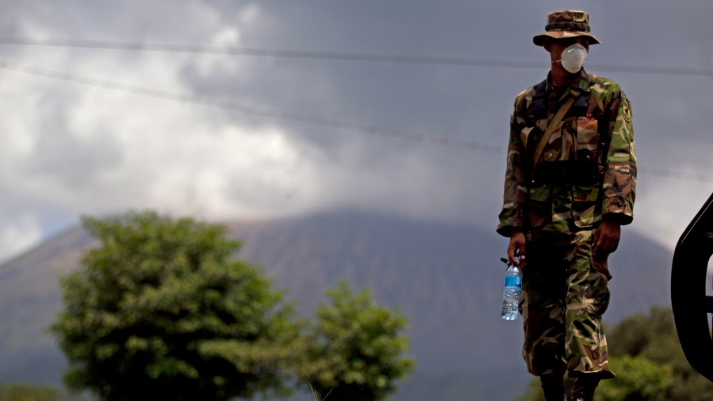 A Nicaraguan soldier wears a protective mask as the San Cristobal volcano, in background, spews smok
