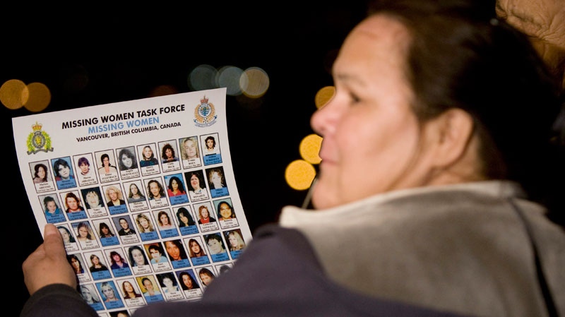 A woman holds up a poster of missing women outside the B.C. Supreme Court in New Westminster, B.C. Friday, Nov. 30, 2007.  (Jonathan Hayward / THE CANADIAN PRESS)