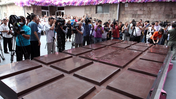 Reporters make images of a huge chocolate bar produced by the Grand Candy factory in the Armenian capital, Yerevan, Saturday, Sept. 11, 2010. (AP / Vahram Bagdasaryan, Photolure)