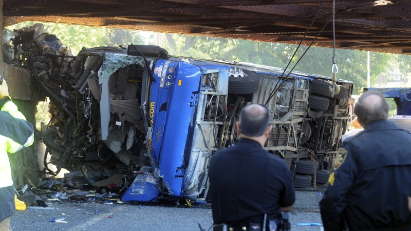 Onondaga County authorities investigate a fatal bus crash on Onondaga Parkway at the railroad bridge in Syracuse, N.Y., Saturday, Sept. 11, 2010. (The Post-Standard / Peter Chen) 