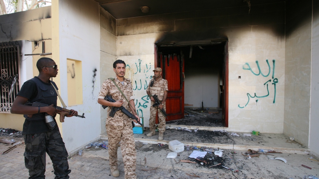 Libyan military guards check one of the U.S. Consulate's burnt out buildings during a visit by Libya