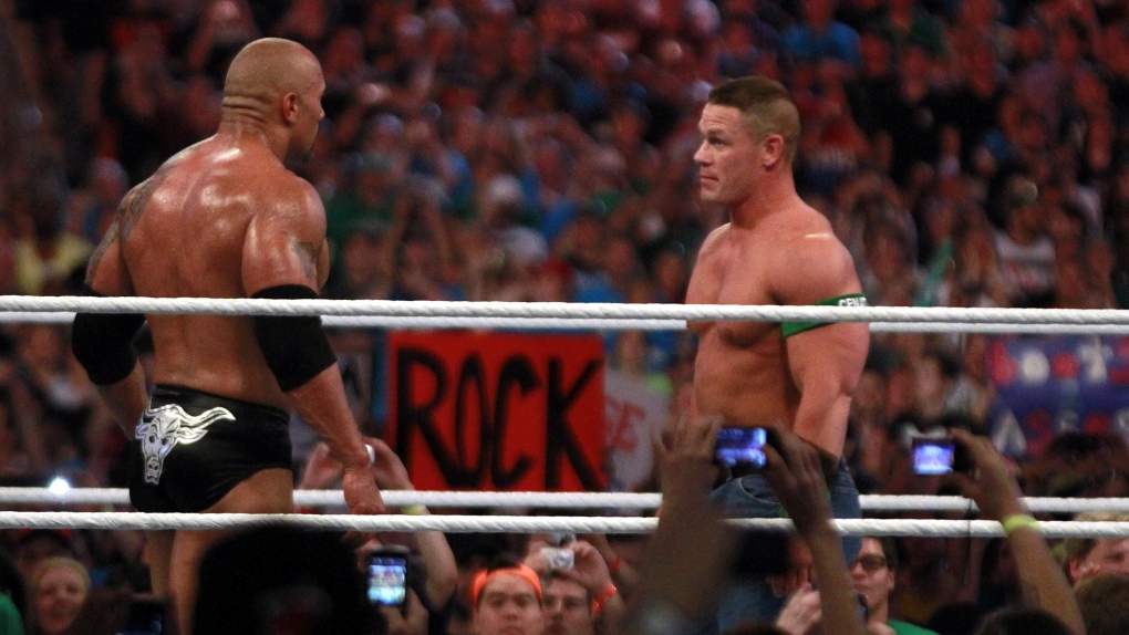 In this photograph taken by AP Images for WWE, Dwyane 'The Rock' Johnson, left, and John Cena face o