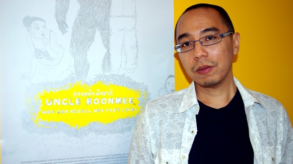 Thai director Apichatpong Weereasethakuli stands in front of a poster advertising his film, in the studio of filmmaker Ron Mann in Toronto on Sept. 17, 2010. (Phil Hahn / CTV.ca)