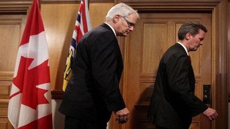 British Columbia Premier Gordon Campbell, left, and Finance Minister Colin Hansen leave a in Victoria, B.C., on March 2, 2010. Columbia's finance minister is trying to put the brakes on demands his government push ahead on debate over the future of the harmonized sales tax. 