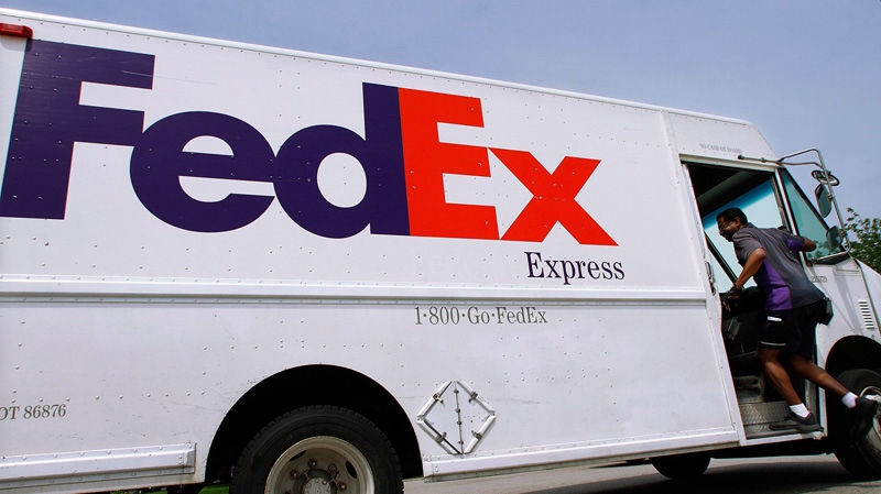 A FedEx employee climbs aboard a delivery truck on June 21, 2011.