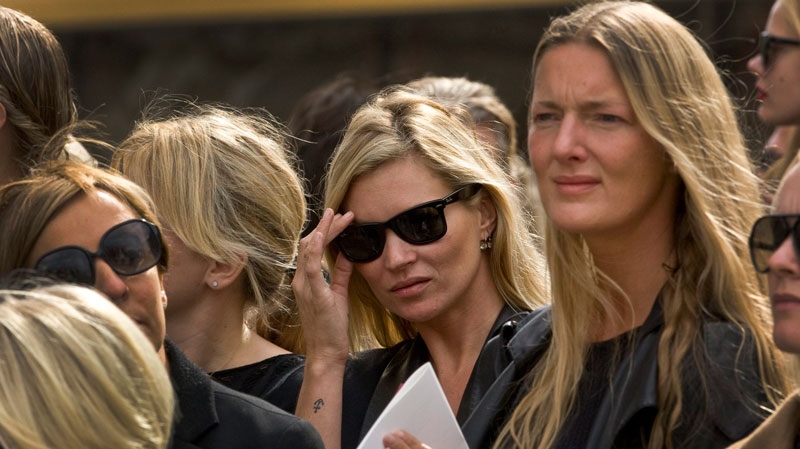 British model Kate Moss, centre, adjust her sunglasses as she listens to Scottish bagpipers playing outside the memorial service for Alexander McQueen at St Paul's Cathedral in London, which takes place during London Fashion Week, in London, Monday, Sept. 20, 2010. (AP / Joel Ryan)