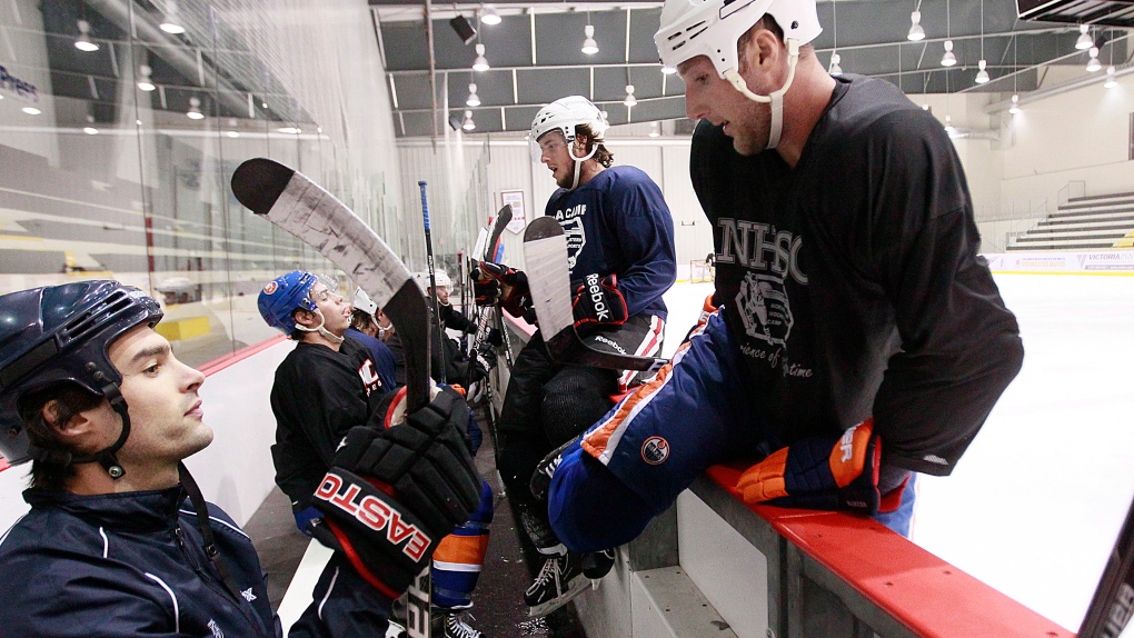 NHL player Cam Barker (right) goes over the boards during a practice with other NHL players