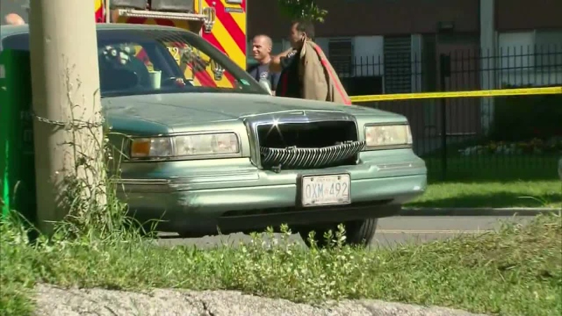 Emergency officials are shown at the scene where a boy was pinned by a vehicle on Thorncliffe Park Drive in Toronto on Saturday, Sept. 22, 2012.