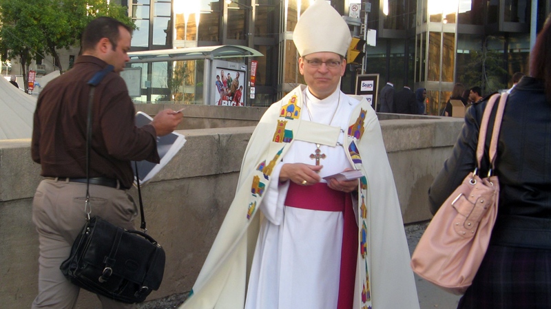 Archbishop Colin Johnson hands out cards outside Union Station in Toronto, Thursday, Sept. 23, 2010. (Pat Hewittw / THE CANADIAN PRESS)  