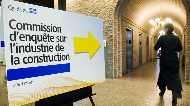A woman walks by a sign outside the Quebec contrsuction industry corruption inquiry on June 4, 2012.