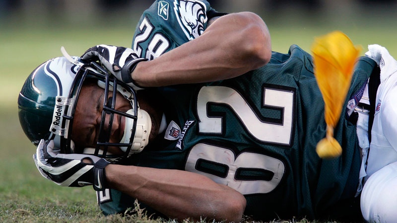 A NFL player lies on the field and holds his head after a hard hit, which caused him to suffer a concession, during the fourth quarter of a football game Sunday, Oct. 26, 2008. (AP / Mel Evans)