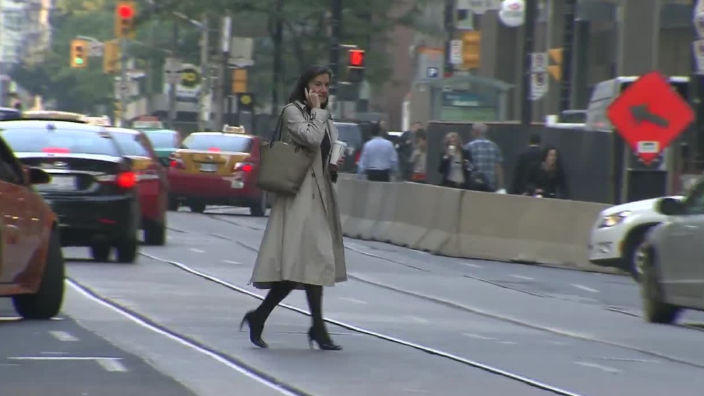 A pedestrian is seen jay walking while talking on a cell phone in downtown Toronto, Thursday, Sept. 
