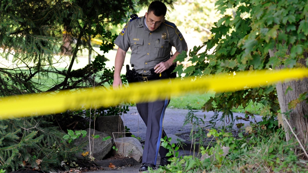 State Trooper Matt Losh emerges from the backyard of a home in New Fairfield, Conn.