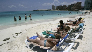 In this photo taken on June 12, 2009, tourists enjoy the beach at the resort city of Cancun, Mexico. (AP Photo/Israel Leal)