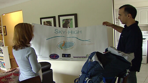Angelo Garcia and Sophie Rose display the banner for their charity climb of Mount Kilimanjaro. They're expecting to reach the summit Sunday, Oct. 14, 2012.