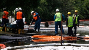 FILE - In this July 30, 2010 file photo, crews clean up oil, from a ruptured pipeline, owned by Enbridge Inc, near booms and absorbent materials where Talmadge Creek meets the Kalamazoo River as in Marshall Township, Mich. Federal investigators are expected to present their findings Tuesday, July 10, 2012 on the likely cause of a pipeline rupture that spilled more than 800,000 gallons of crude oil into the river nearly two years ago. (AP Photo/Paul Sancya, File)