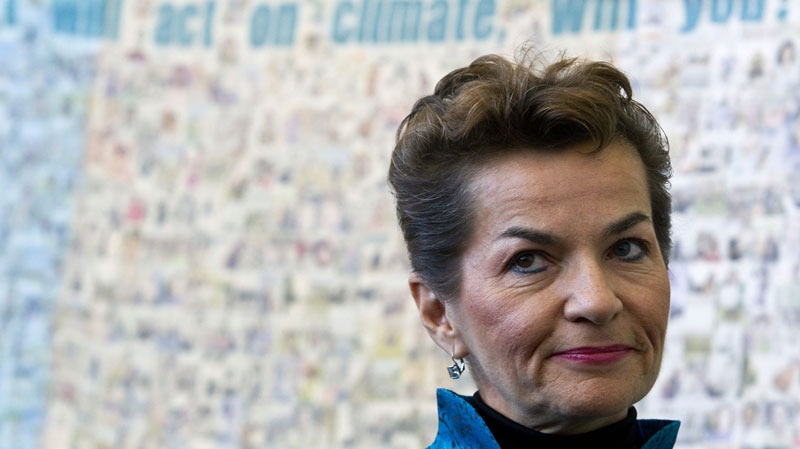 UN climate chief Christiana Figueres stands in front of a poster made by Green Peace before the opening of the United Nations Climate Change Conference in Tianjin, China, Monday, Oct. 4, 2010. (AP Photo/Alexander F. Yuan) 