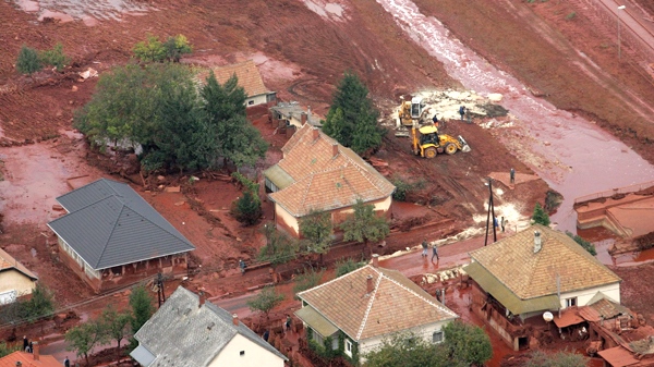 An aerial view of the red mud covered streets and rescue workers engaged in cleaning operation with two excavators in Kolontar, 167 kilometres southwest of Budapest, Hungary, taken on Tuesday, Oct. 5, 2010. (AP / MTI, Gyoergy Varga)