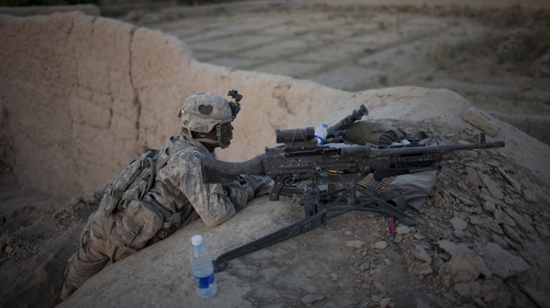 U.S. soldier PFC Sheldon Green from Bravo Company 2-502 Infantry Regiment, 101st Airborne Division, perform guard duty from an outpost near Forward Operation Base Howz-e-Madad, Zhari district, Kandahar province, Afghanistan, Wednesday, Oct. 6, 2010. (AP Photo/Rodrigo Abd)