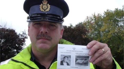 An OPP officer holds up a poster with information about the hit and run death of Lucas Shortreed.