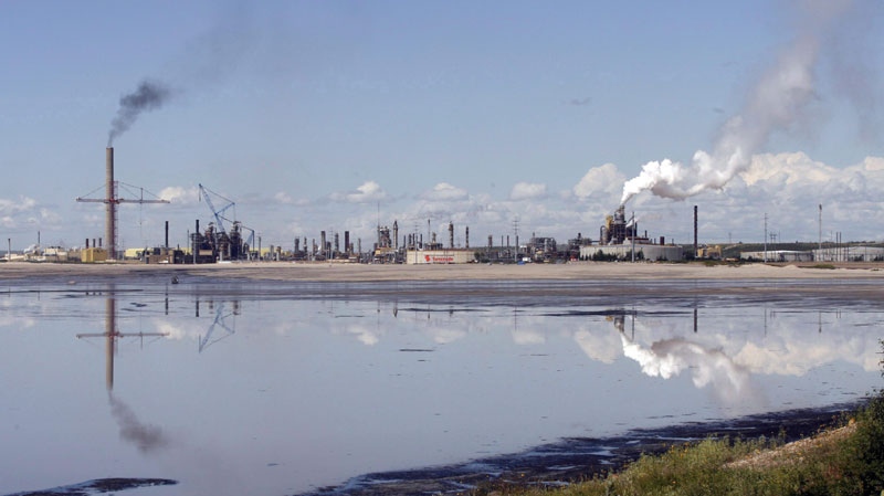 A tailings pond reflects the Syncrude oilsands mine facility near Fort McMurray, Alta., Wednesday, July 9, 2008. (THE CANADIAN PRESS/Jeff McIntosh)