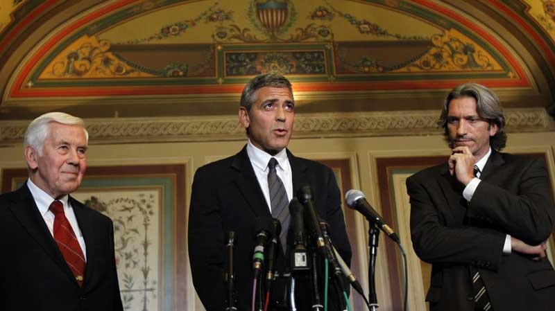 Actor George Clooney, center, talks with the media with Chairman of the Senate Foreign Relations Committee Ranking Member, Sen. Richard Lugar, R-Ind., left, and author and activist John Prendergast after their meeting about the situation in Sudan, on Capitol Hill in Washington Tuesday, Oct. 12, 2010. (AP Photo/Alex Brandon)