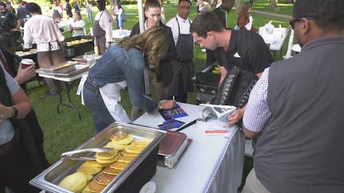 Alberta Premier Danielle Smith autographs a photo for supporter Tom Johnson during the KDays pancake breakfast at the legislature on July 16, 2026. (Sean McClune / CTV News Edmonton)
