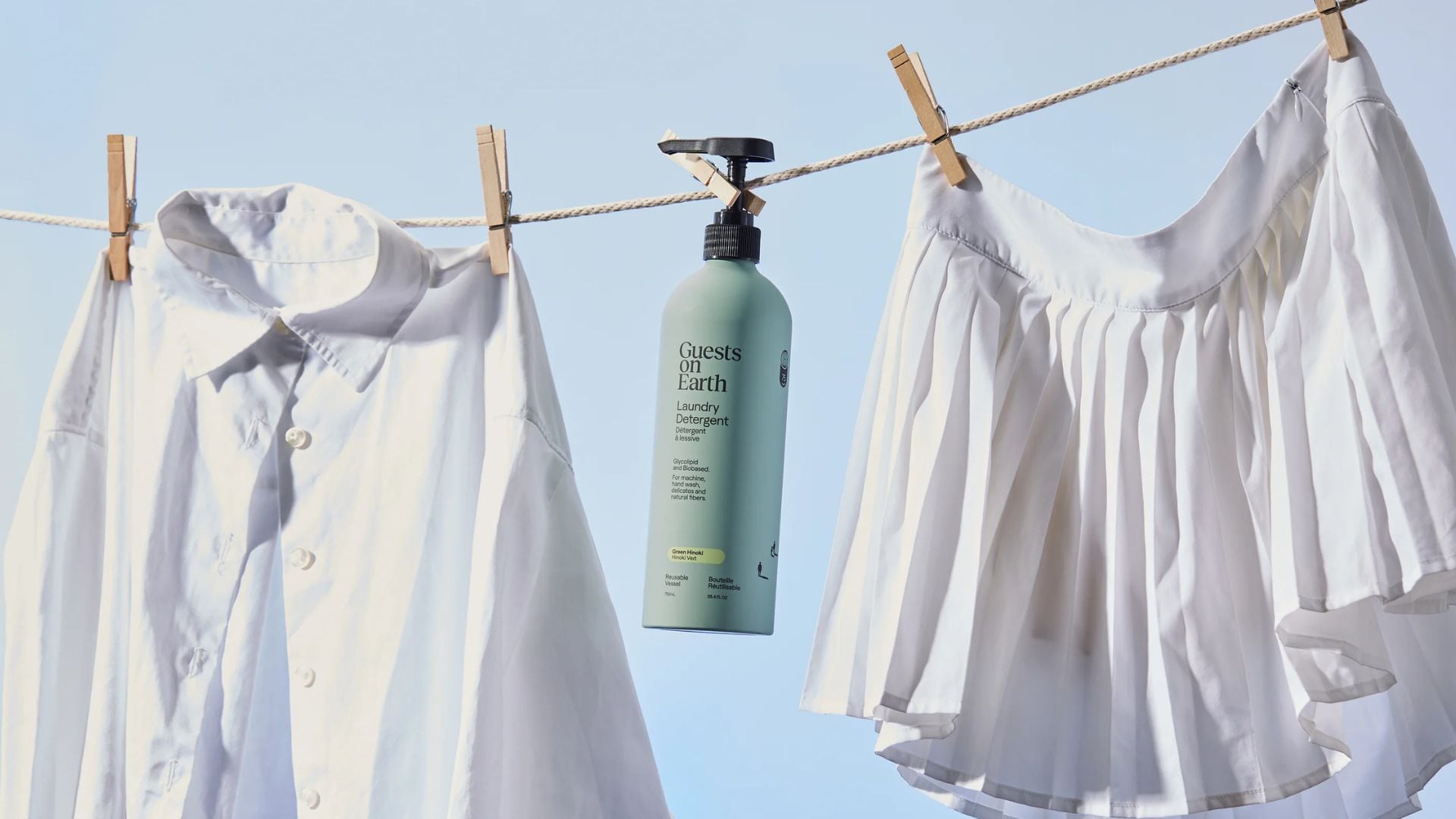 A bottle of Guests on Earth detergent hanging from a clothesline.