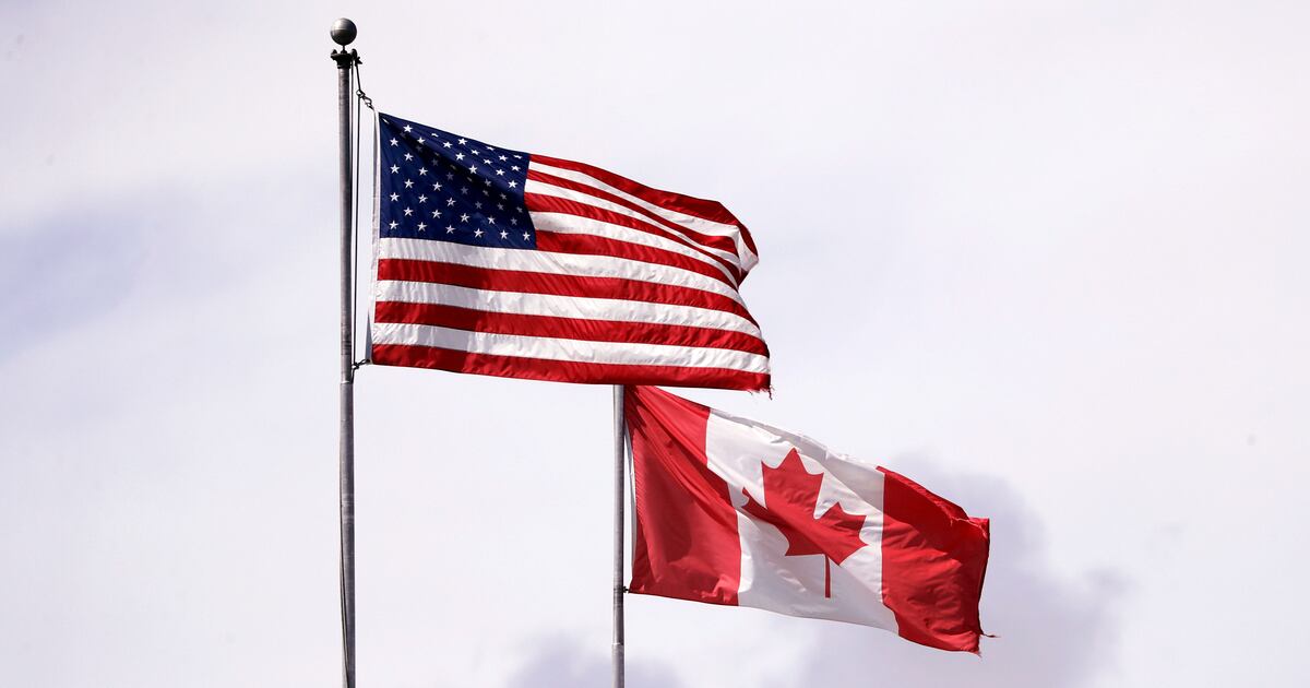 U.S. and Canadian flags fly atop the Peace Arch at Peace Arch Historical State Park on the border with Canada, in Blaine, Wash., Sunday, May 17, 2020. (AP Photo/Elaine Thompson)