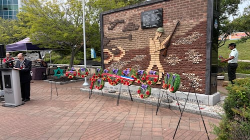 A military monument is pictured with wreaths in front of it.