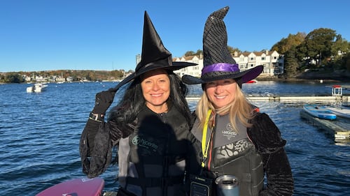 Two women pose for a photo while dressed up as witches.