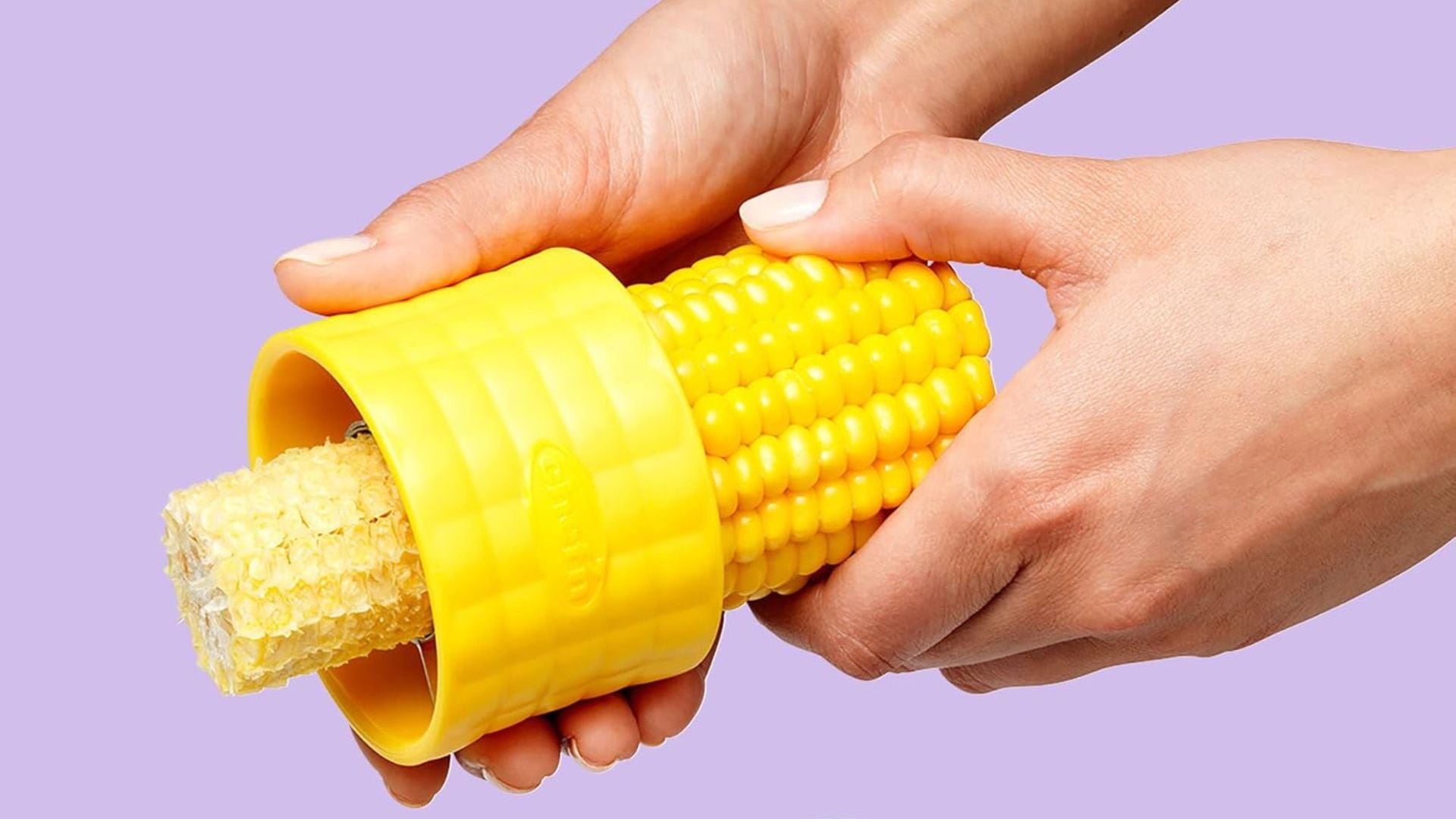 A person shucking a cob of corn with a Chef'n tool.