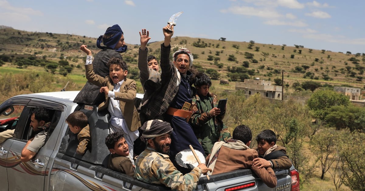 Yemeni civilians celebrate while riding in the back of a pickup truck in the Bani Matar district, Yemen, Saturday, Sept. 12, 2026, as they follow a convoy carrying Houthi prisoners freed in Mokha on its way to Sanaa following the Houthi takeover of the southern Red Sea port city. (AP Photo/STR)