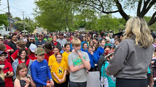 A woman addresses a crowd of students.