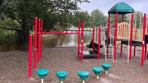 The field surrounding a playground is flooded.