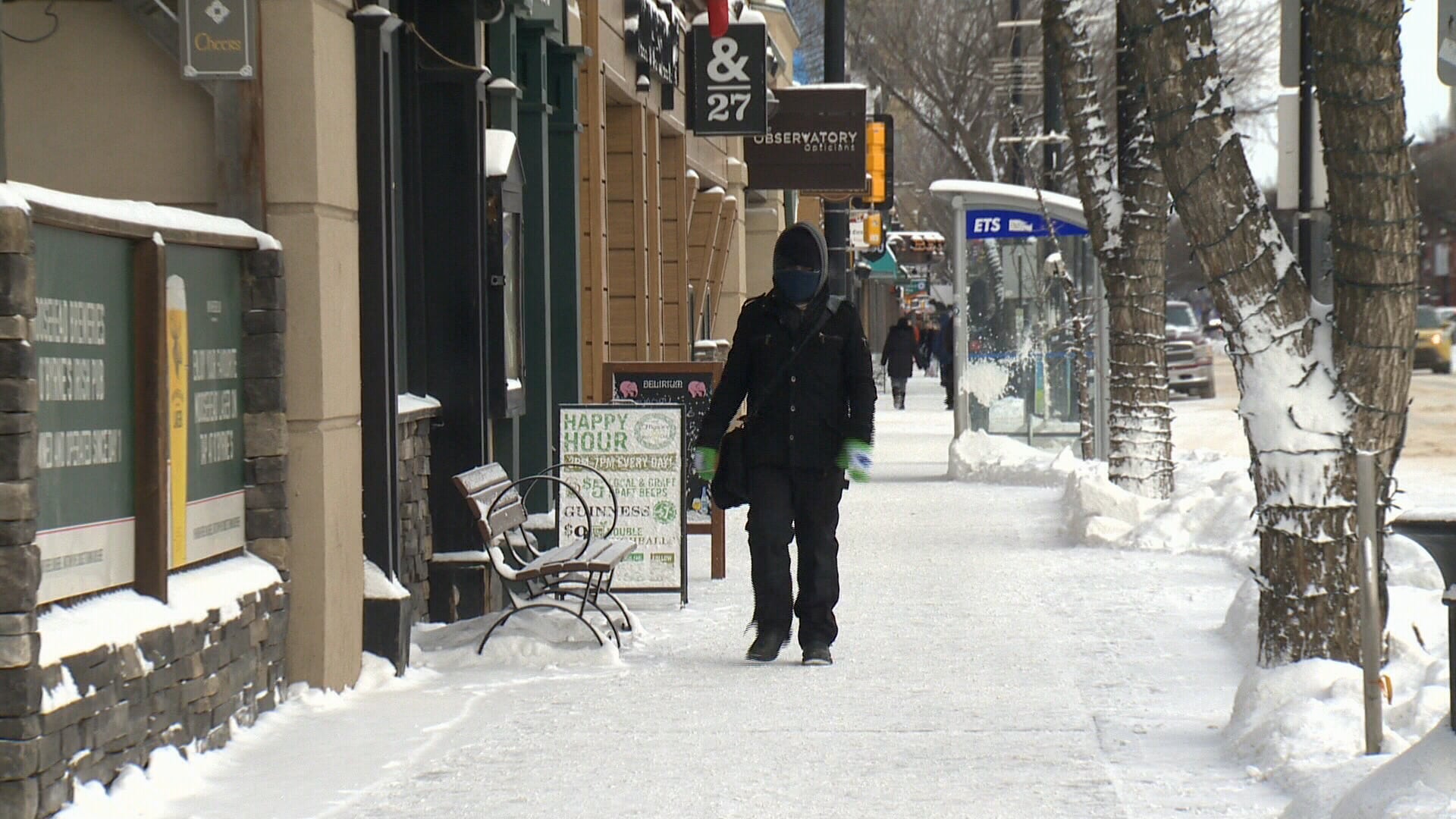 A pedestrian on Whyte Avenue in Edmonton in winter.