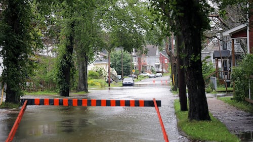 A barricade is put up in front of a flooded street.