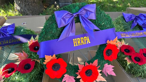 A wreath is pictured with a purple ribbon.