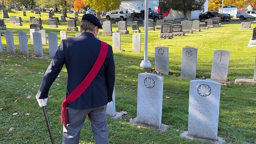 A man walks through a cemetery.
