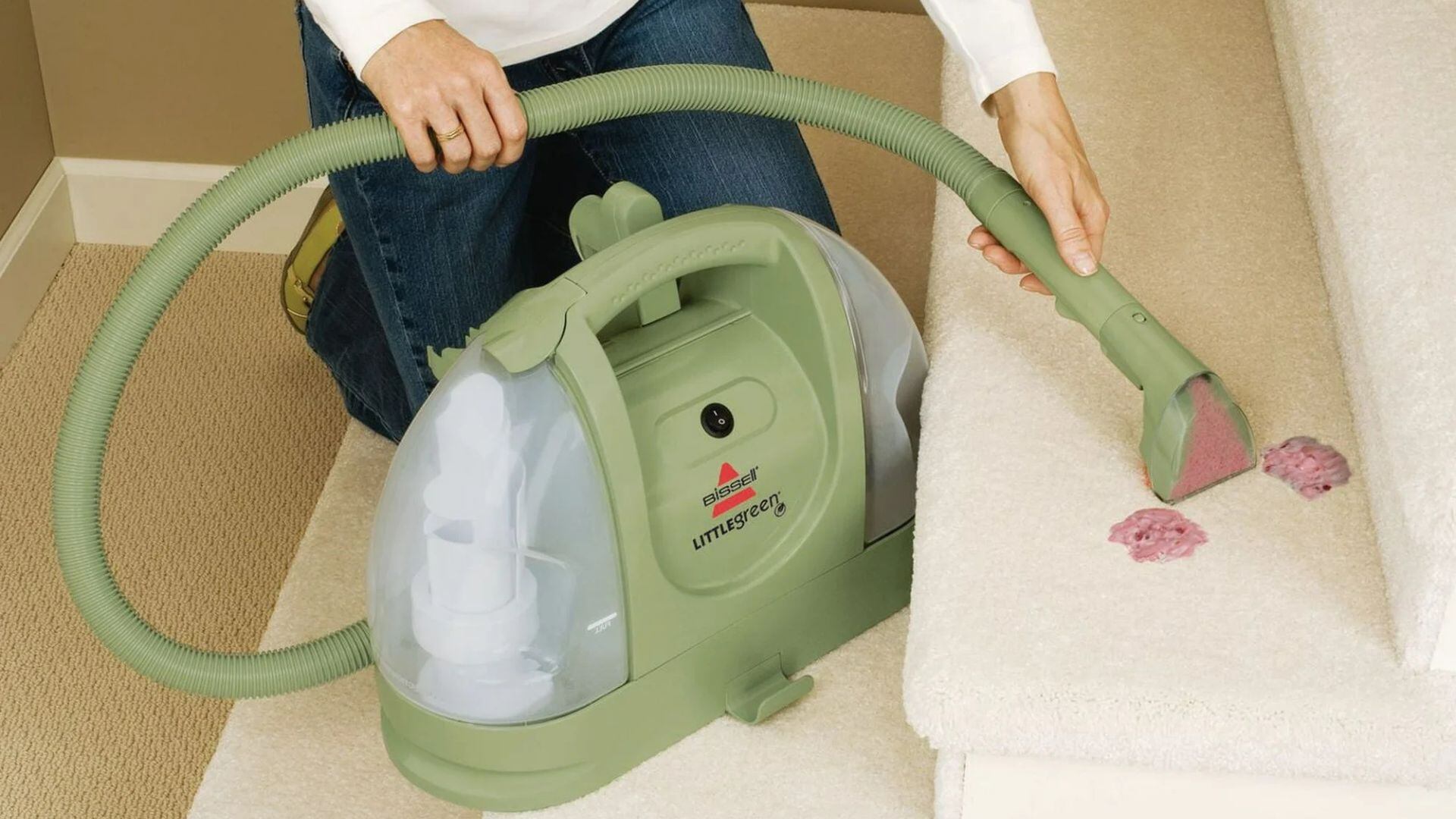 A person using a carpet cleaner on their stairs.