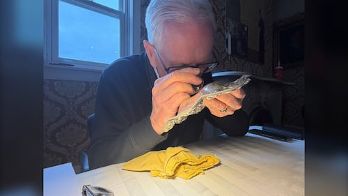 A man is pictured looking at an antique object.