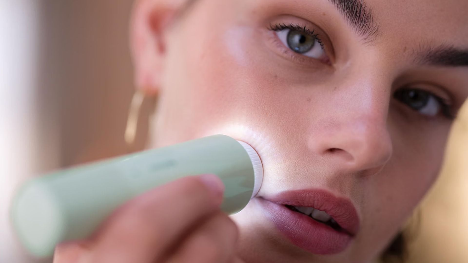 A person using the Philips Facial Hair Remover on their upper lip.