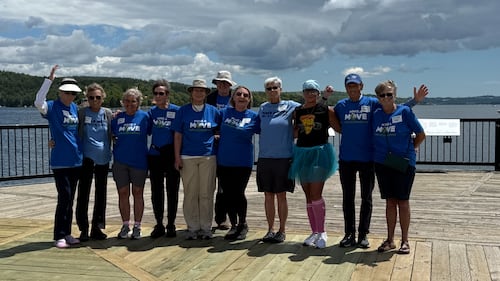 A group of people pose for a photo on a boardwalk.