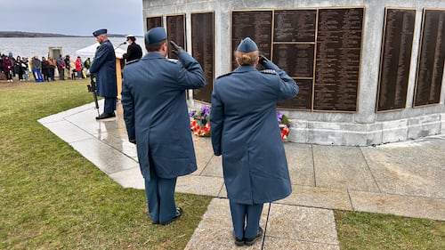 Members of the Navy salute a war memorial.