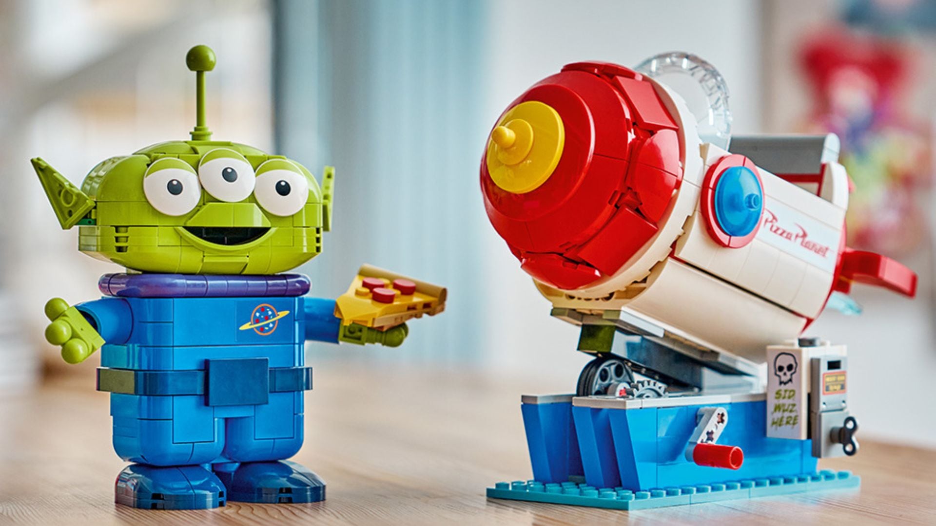 A Toy Story Lego kit on a table, showing a built alien and a rocket.