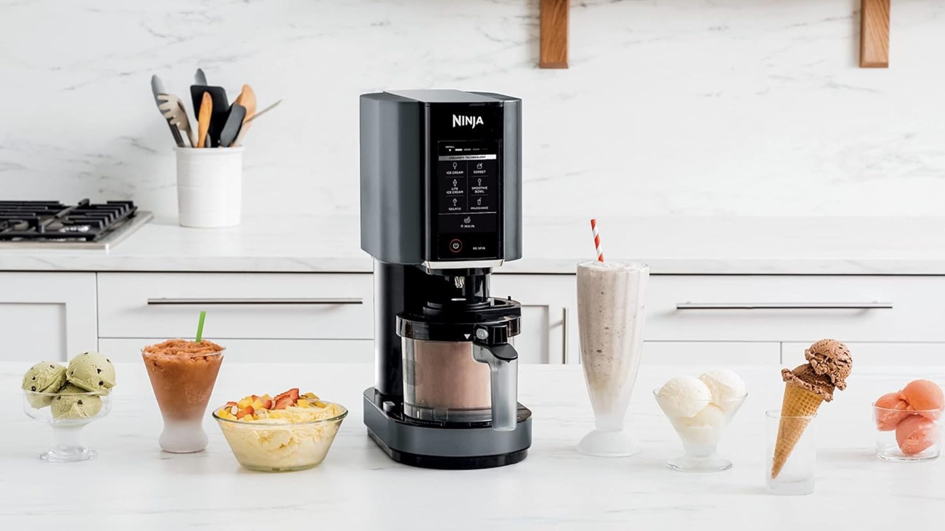 the Ninja CREAMi on a counter with ice cream, milkshakes, smoothies, and sorbet around it