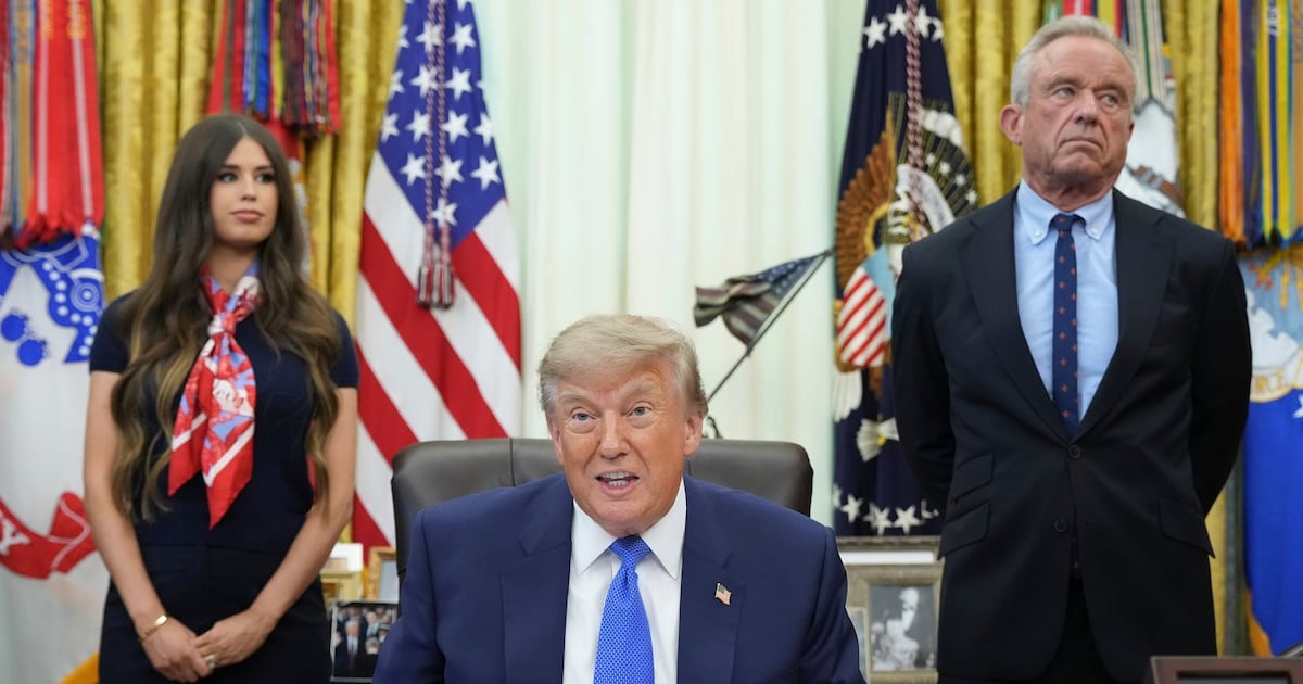 President Donald Trump speaks as Health and Human Services Secretary Robert F. Kennedy Jr., right, and Jayme Franklin listen during a meeting to sign an executive order about vaccines, Monday, Aug. 10, 2026, in the Oval Office of the White House in Washington. (AP Photo/Jacquelyn Martin)