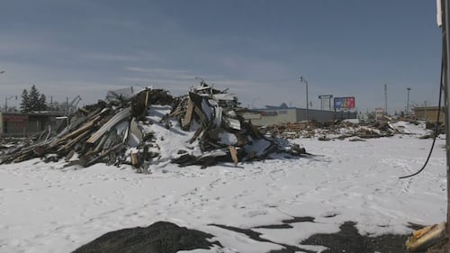 A large pile of burnt wood from the Jasper Place Hotel sits unattended on April 1, 2026. (Galen McDougall/CTV News Edmonton)