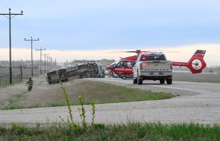 A STARS medical helicopter and a police truck are shown on Highway 672 near Beaverlodge, Alta., west of Grande Prairie, Alta., after a bus rollover resulted in several passengers being taken to hospital on Wednesday, May 13, 2026. THE CANADIAN PRESS/William Vavrek
