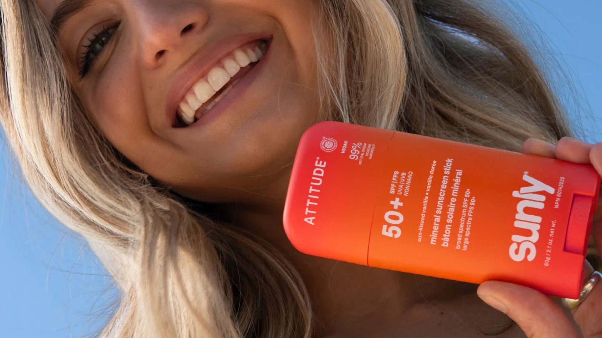 A person holding an ATTITUDE Sunscreen Stick.